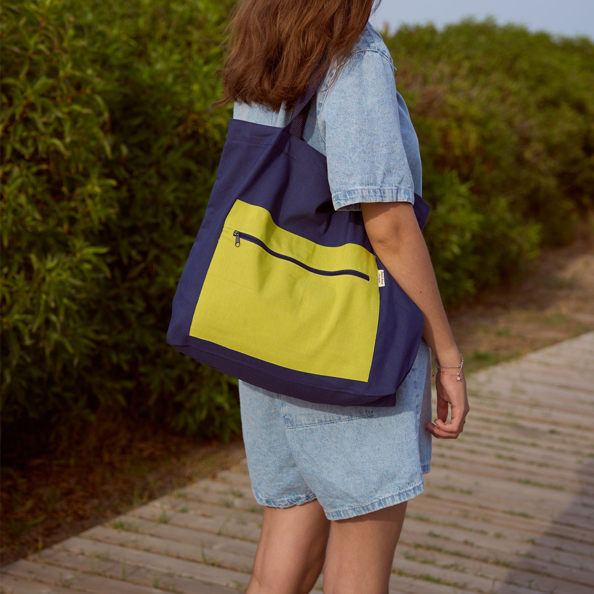 Bolso tote de tela bicolor azul marino y verde pistacho Vista lateral del bolso tote de tela azul y verde pistacho