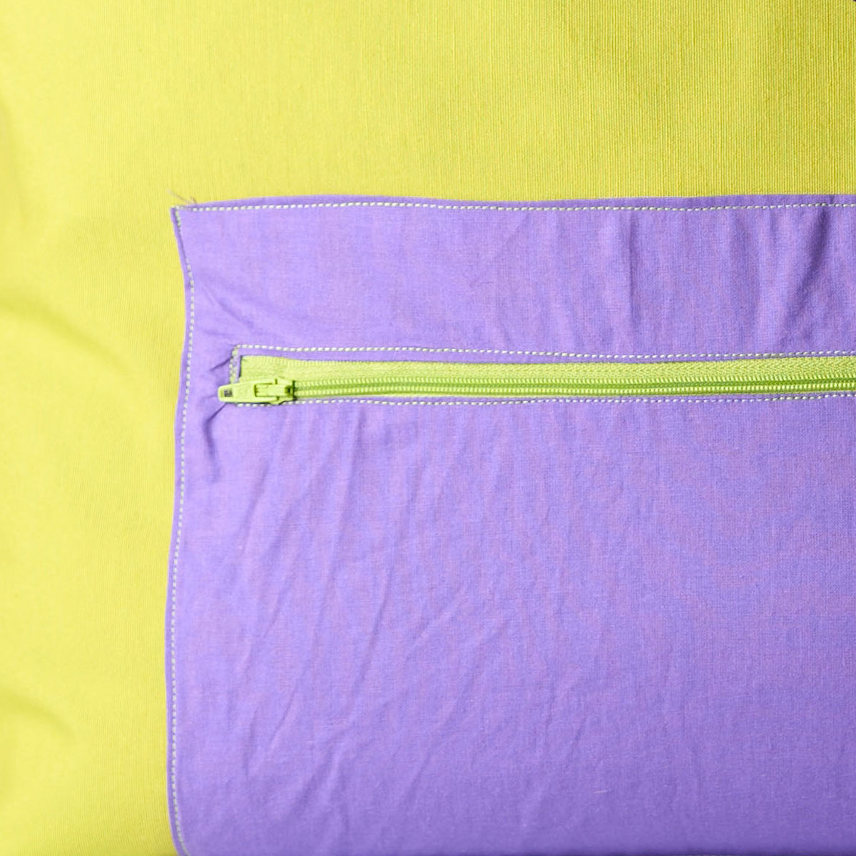 Bolso tote de tela bicolor verde pistacho y lila Detalle del bolsillo exterior con cremallera en lila del bolso tote