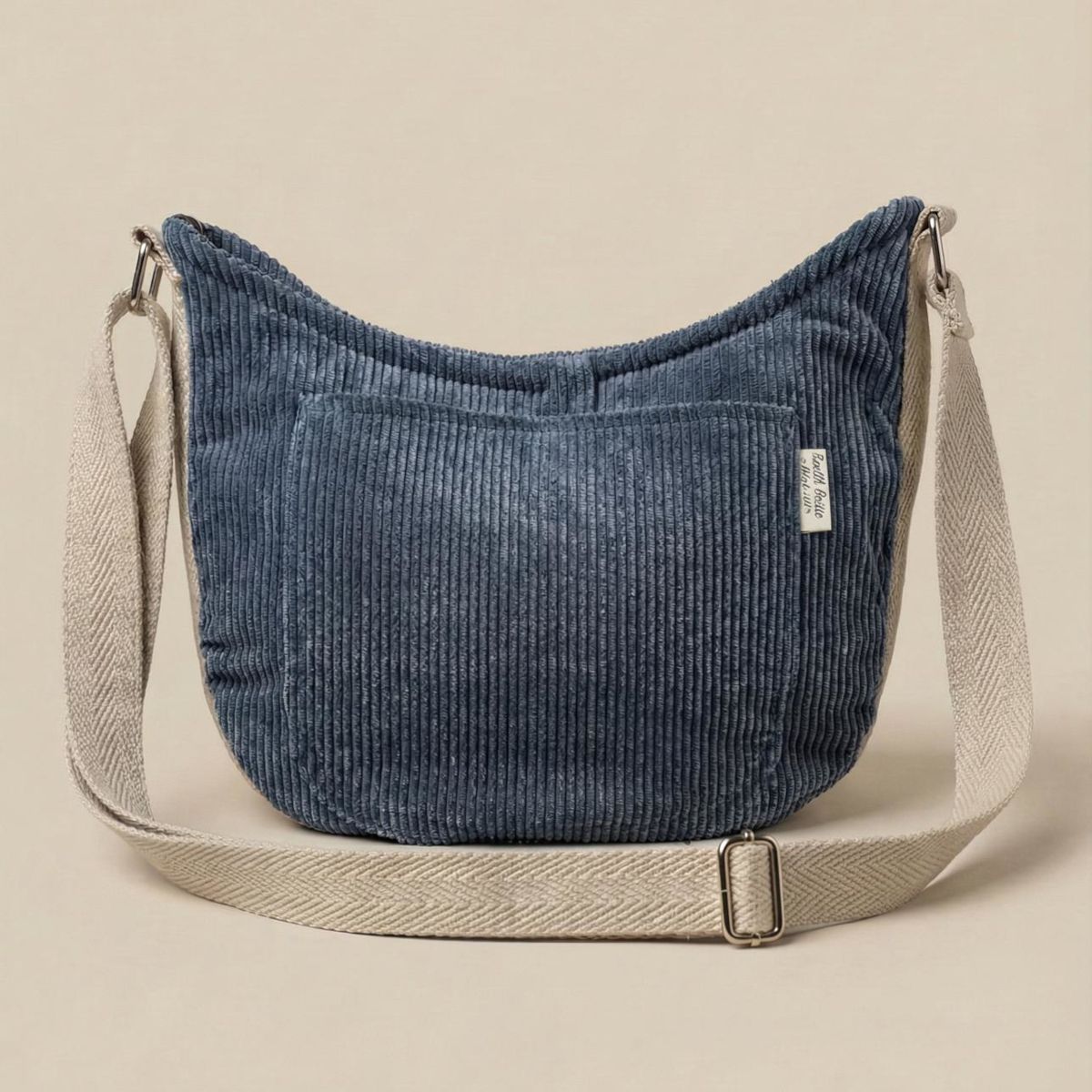 Bolso bandolera de pana con bolsillo exterior Bolso bandolera de pana azul con bolsillo exterior frontal y correa extendida, vista frontal