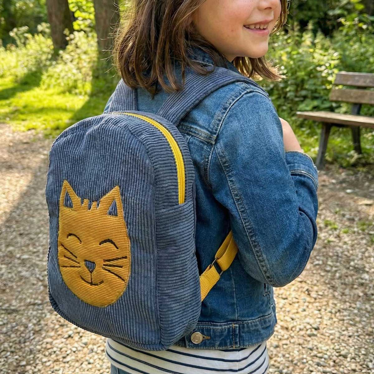 Mochila infantil de pana con gato Mochila infantil de pana con gato llevada por una niña