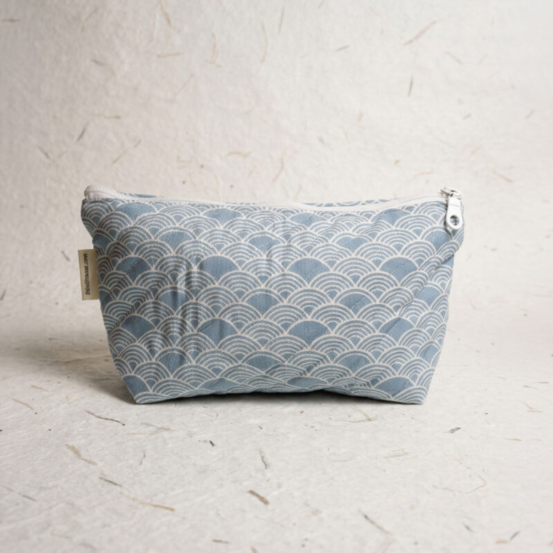 Neceser de tela azul con estampado de ondas y cremallera blanca