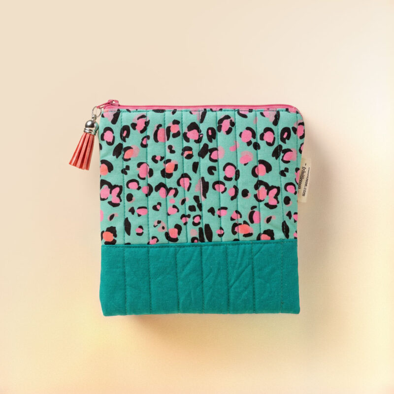 Estuche de tela estampado en verde y rosa con cremallera y diseño acolchado
